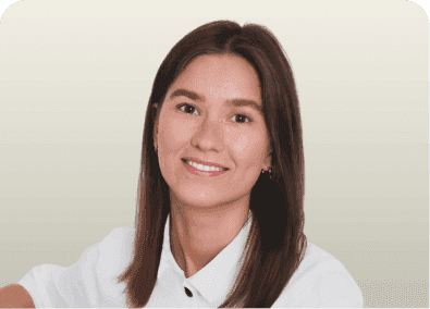 A smiling young woman with long brown hair wearing a white collared shirt.