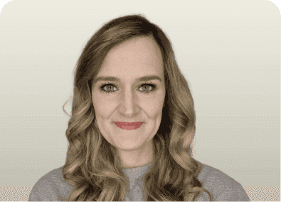 Young woman with long wavy brown hair, light eyes, and a subtle smile.