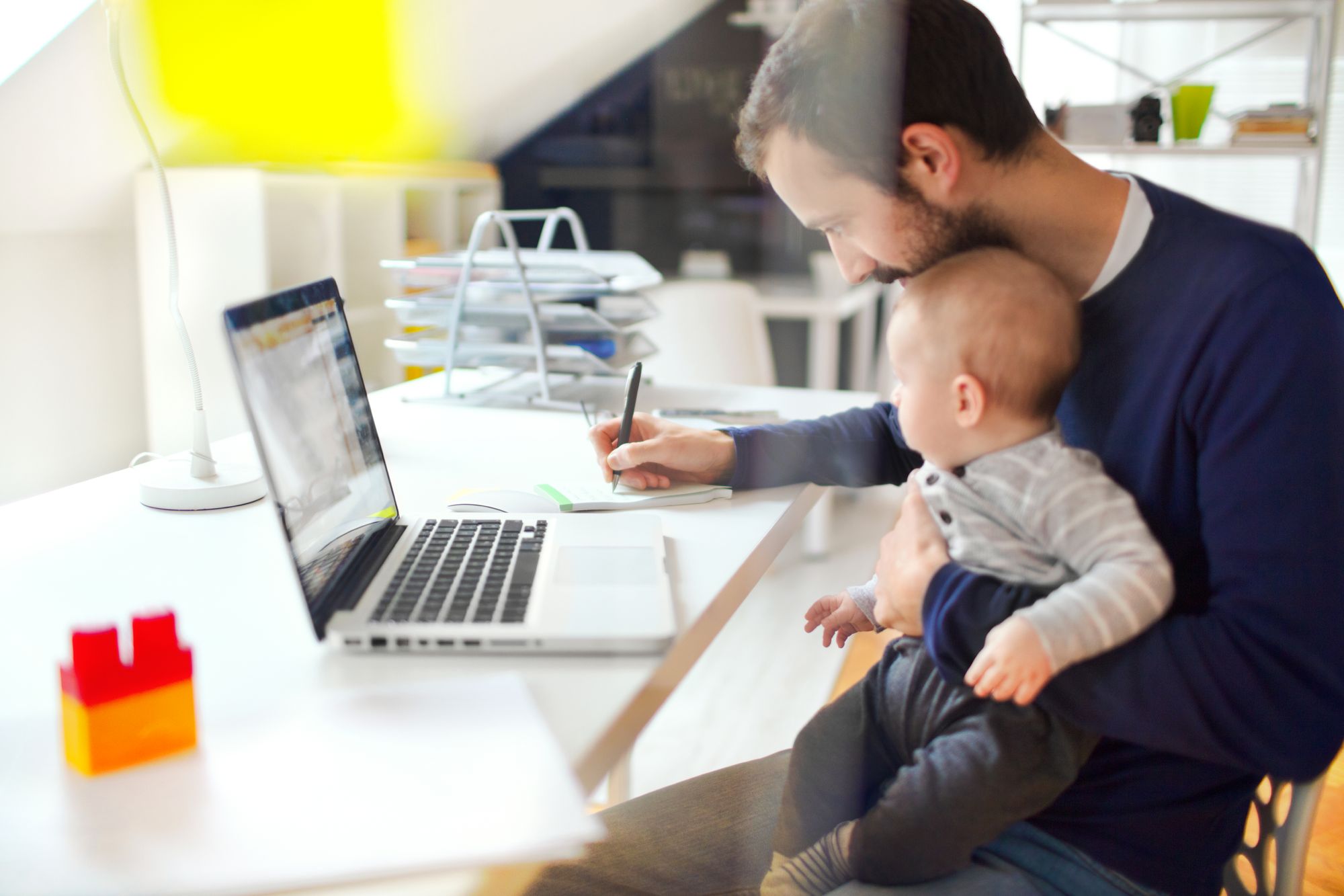 father working with baby on lap